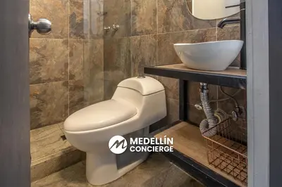 a bathroom with a white toilet and a sink at 2BR House Jacuzzi & AC in Poblado Manila in Medellín
