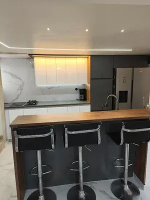 a kitchen with two bar stools at a counter at Hermoso Apto Cerca centro comercial Molinos in Medellín