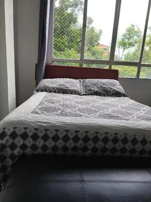 a bed sitting in a room with a window at Hermoso Apto Cerca centro comercial Molinos in Medellín