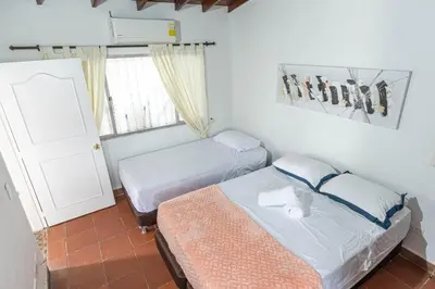 a small bedroom with two beds and a window at Villa Armonía - Santa Fé de Antioquia in Santa Fe de Antioquia