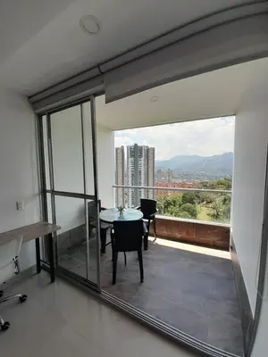 a room with a table and a balcony with a view at Superior apto vista campestre in Sabaneta