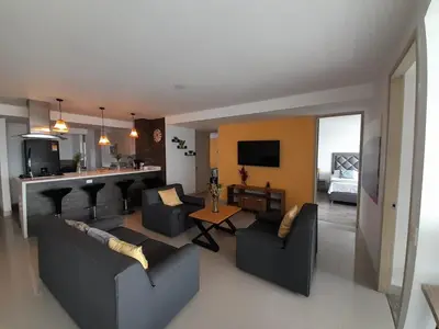 a living room with two couches and a kitchen at Superior apto vista campestre in Sabaneta