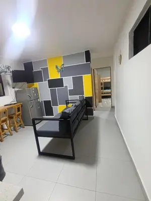 a living room with a black couch and a geometric wall at S21 COMODO APARTAMENTO EN LAURELES ESTADIo 2 HABT 2 BAÑOS in Medellín