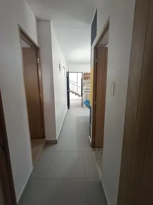 a hallway with white walls and white floors and wooden doors at S21 COMODO APARTAMENTO EN LAURELES ESTADIo 2 HABT 2 BAÑOS in Medellín
