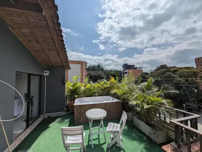a patio with a table and chairs on a balcony at Amplio Apto con Jacuzzy Terraza 2B 4hab Laureles in Medellín
