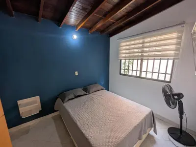 a bedroom with a bed and a blue wall at Amplio Apto con Jacuzzy Terraza 2B 4hab Laureles in Medellín