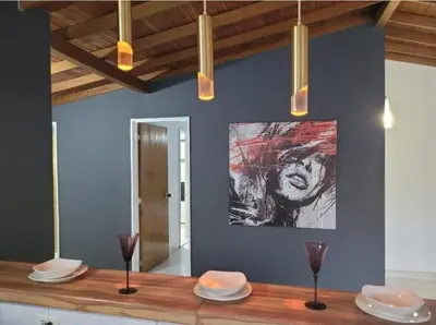 a dining table with plates and glasses and a painting on the wall at Amplio Apto con Jacuzzy Terraza 2B 4hab Laureles in Medellín