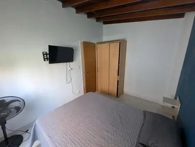 a bedroom with a bed and a tv on the wall at Amplio Apto con Jacuzzy Terraza 2B 4hab Laureles in Medellín