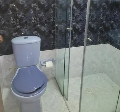 a bathroom with a toilet and a glass shower at Amplio Apto con Jacuzzy Terraza 2B 4hab Laureles in Medellín
