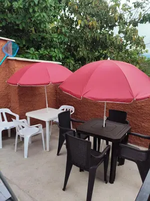 two tables and chairs with red umbrellas on a patio at Encanto colonial in Sopetran