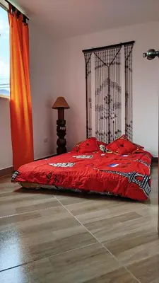 a bedroom with a bed with a red comforter at DESTINY Apto villas del Río in San Rafael
