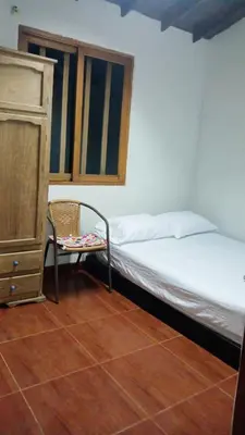 a bedroom with a bed and a chair and a dresser at Refugio en el arroyo in San Carlos