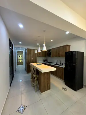a kitchen with a island and a black refrigerator at Apartamento amplio y moderno cerca al parque in Jardin