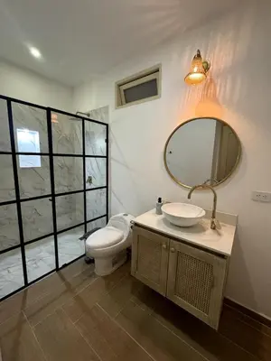 a bathroom with a toilet and a sink and a mirror at Apartamento amplio y moderno cerca al parque in Jardin
