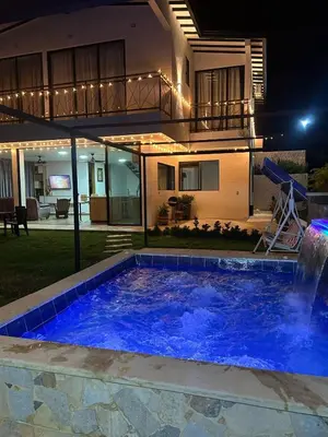 a swimming pool in front of a house at night at Villa Los Pinos in Sopetran