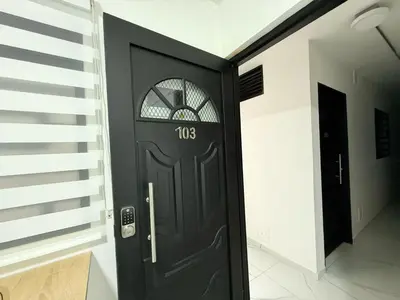 a black door with a number on it in a hallway at Aparta estudio 103 - Casa bendita in Medellín