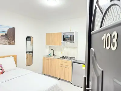 a bedroom with a bed and a kitchen with a stove at Aparta estudio 103 - Casa bendita in Medellín