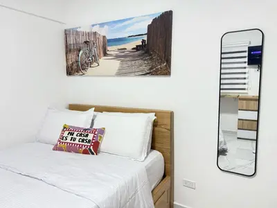 a bedroom with a bed and a mirror at Aparta estudio 103 - Casa bendita in Medellín