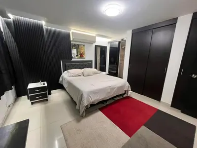 a bedroom with a bed and a red rug at El Poblado Apto cerca a Parque Lleras y Provenza in Medellín