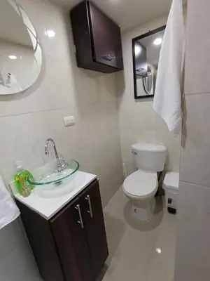 a bathroom with a sink and a toilet and a mirror at El Poblado Apto cerca a Parque Lleras y Provenza in Medellín
