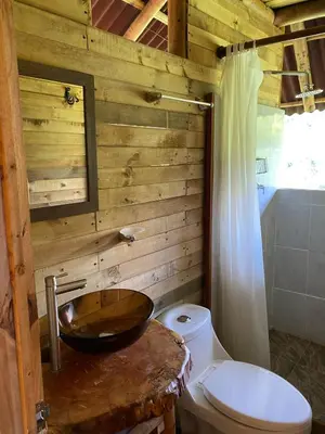 a wooden bathroom with a sink and a toilet at Glamping Falan Tolima in Falan