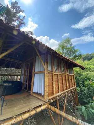 a small wooden house with a porch at Glamping Falan Tolima in Falan