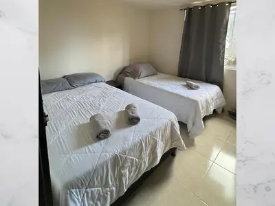 two beds with towels on them in a room at Casa amoblada 15 personas 6 habitaciones 4 baños - Frente al terminal y cable aereo, Cerca de Expoferias, Bosque Popular y Termales del Otoño in Manizales