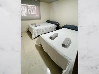 two beds in a room with towels on them at Casa amoblada 15 personas 6 habitaciones 4 baños - Frente al terminal y cable aereo, Cerca de Expoferias, Bosque Popular y Termales del Otoño in Manizales