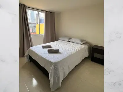 a bedroom with a bed with two towels on it at Hospedaje Gladys in Manizales