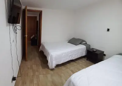 a hotel room with two beds and a television at Hospedaje Gladys in Manizales