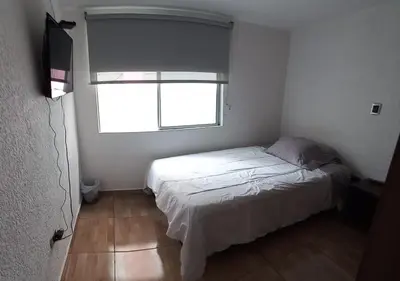 a small bedroom with a bed and a window at Hospedaje Gladys in Manizales