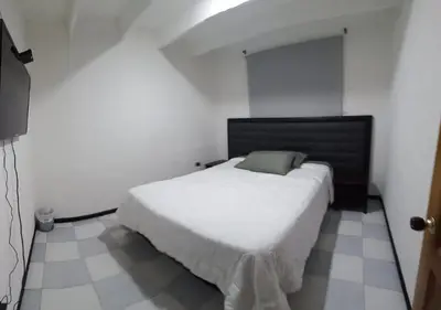 a bedroom with a white bed in a room at Hospedaje Gladys in Manizales