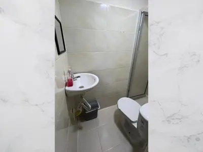 a white bathroom with a toilet and a sink at Hospedaje Gladys in Manizales