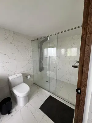 a bathroom with a toilet and a glass shower at Alojamiento Privado en Avenida Principal in Manizales
