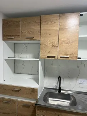 a kitchen with a sink and wooden cabinets at Alojamiento Privado en Avenida Principal in Manizales