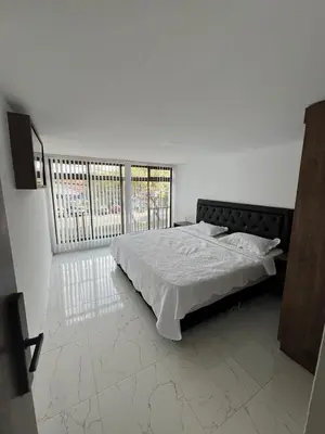 a bedroom with a bed and a large window at Alojamiento Privado en Avenida Principal in Manizales
