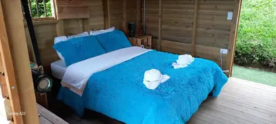 a bedroom with a bed with blue sheets and towels at Entre Colinas Lodge in El Peñol