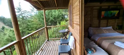 a room with a bed and a balcony in a cabin at Entre Colinas Lodge in El Peñol