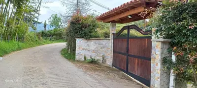 a house with a wooden gate on a road at Entre Colinas Lodge in El Peñol