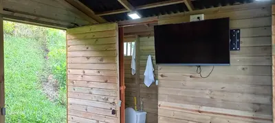 a flat screen tv hanging on a wooden wall at Entre Colinas Lodge in El Peñol