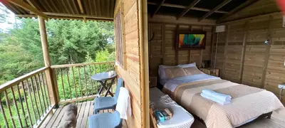 a room with a bed on a balcony at Entre Colinas Lodge in El Peñol