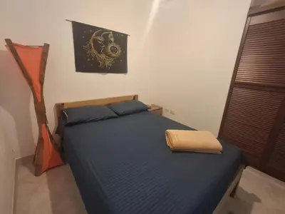 a bedroom with a bed with a blue comforter at Hostal Naty luna - sede alterna in Jardin