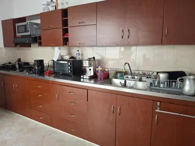 a kitchen with wooden cabinets and a counter top at Hostal Naty luna - sede alterna in Jardin