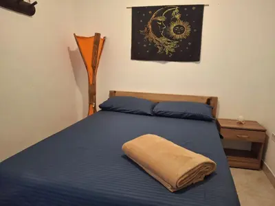 a bedroom with a blue bed with a towel on it at Hostal Naty luna - sede alterna in Jardin