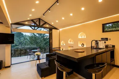 a kitchen and living room with a counter and a large window at Villa Kobus in San Antonio de Pereira