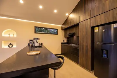 a kitchen with a counter and a black refrigerator at Villa Kobus in San Antonio de Pereira