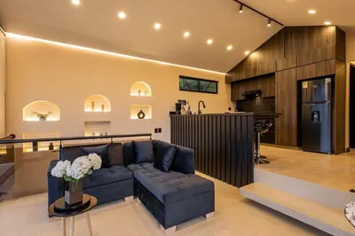 a living room with a couch and a kitchen at Villa Kobus in San Antonio de Pereira
