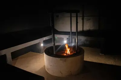 a fireplace with a fire in it in the dark at Villa Kobus in San Antonio de Pereira