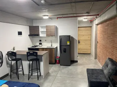 a kitchen with a refrigerator and a table and chairs at Medellín Apartment Loft in Medellín