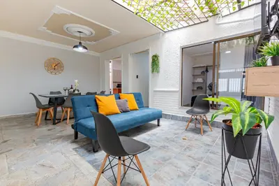 a living room with a blue couch and a table at Great family home near the stadium and beautiful neighborhood in Medellín